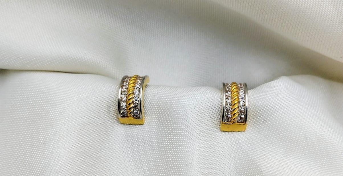 Two-tone curved huggie hoops with diamond borders and central gold rope detail